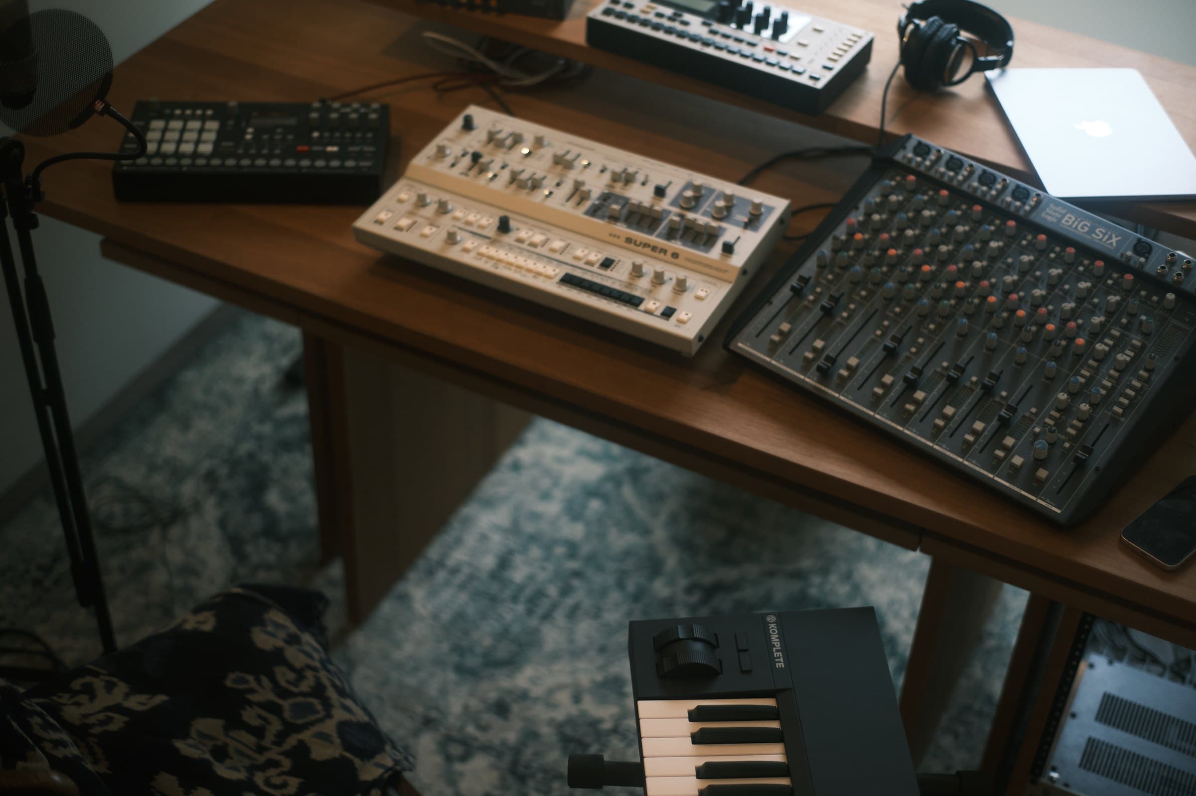 シンセサイザーと SSL Big Six ミキシングコンソールが並ぶスタジオデスク